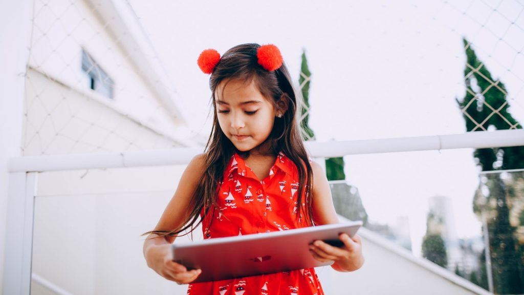 child holds iPad